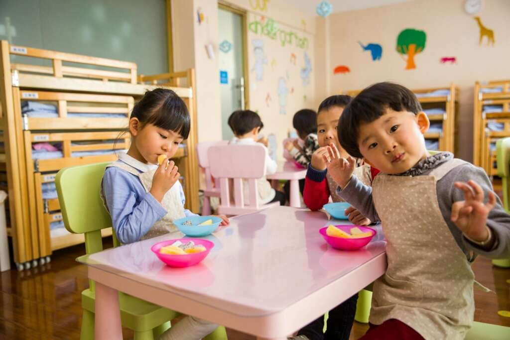 Children in a daycare eating at the table