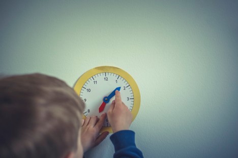  A child working with a paper clock at a Brampton Daycare Center