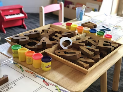 Paints and wooden letters for kindergarten children