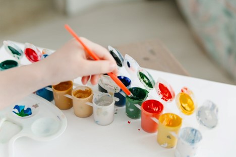 A child using paints and brushes