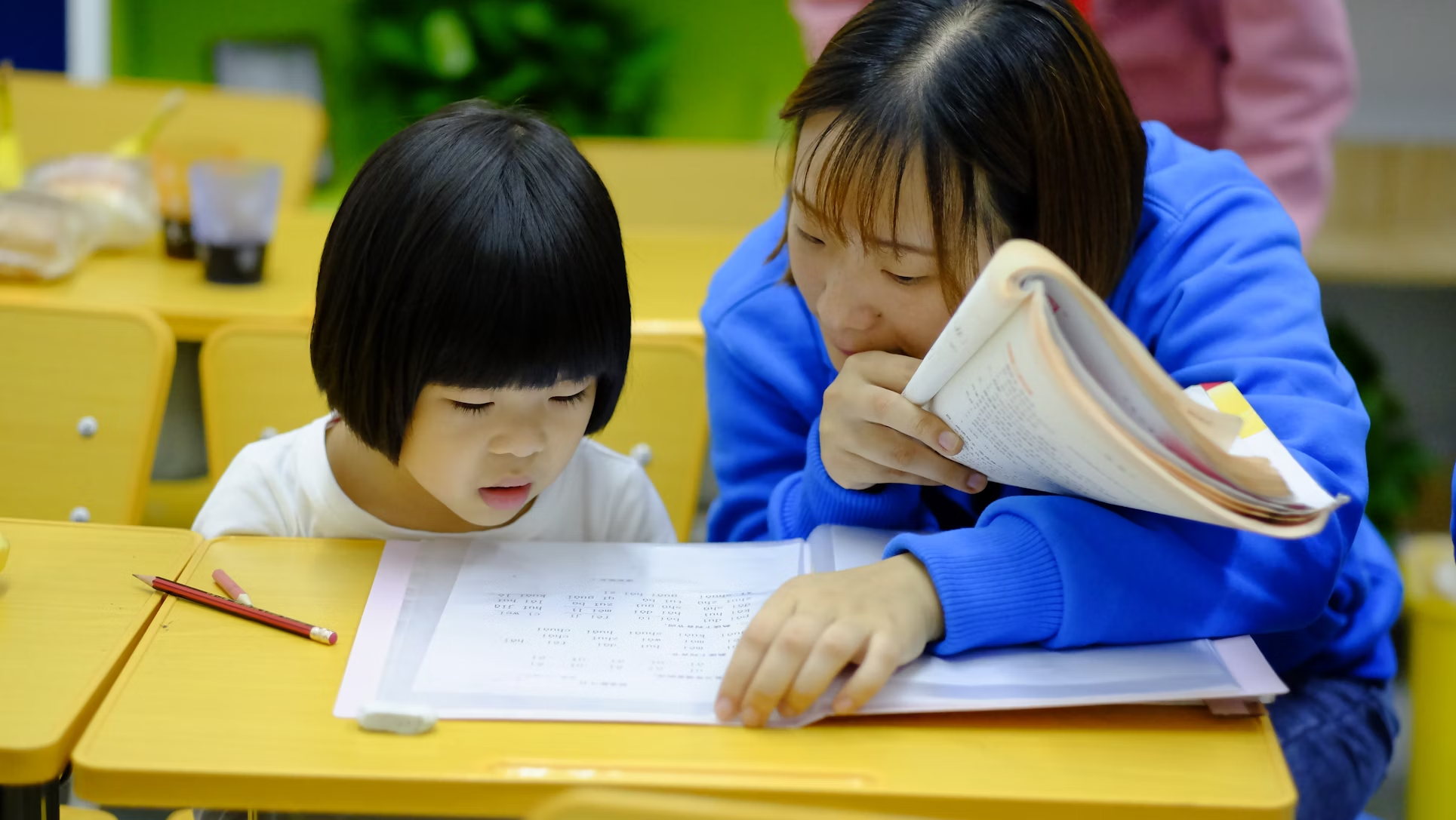 A teacher helping out a student